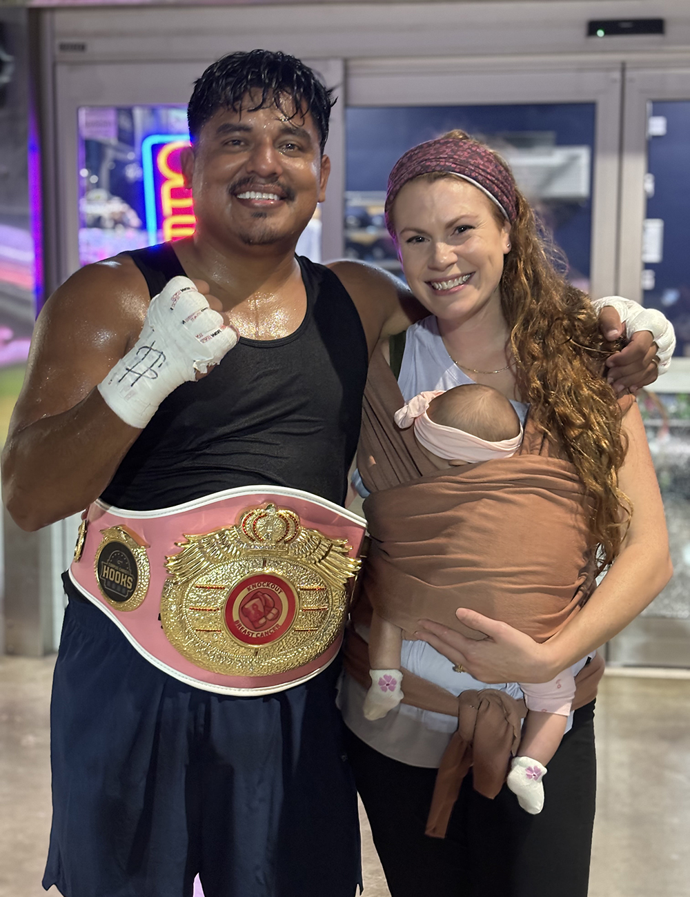Gilbert and family wearing a boxing belt
